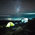 Backpacker hostel dorm tent and communal firepit at a budget safari camp, Kenya