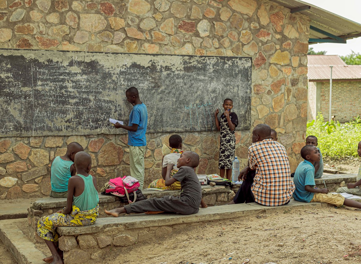 rural African schoolchildren gathered outside their school building, the kind of community school conservancy tourism revenue helps fund