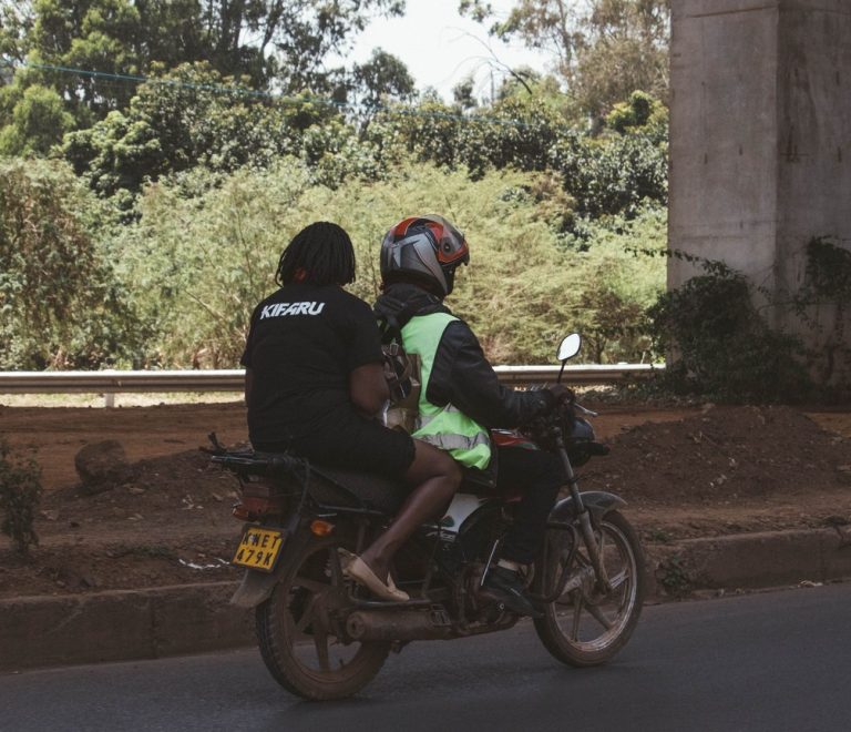 a solo woman traveler with a daypack walking confidently through a quiet, leafy Nairobi neighborhood street in daylight
