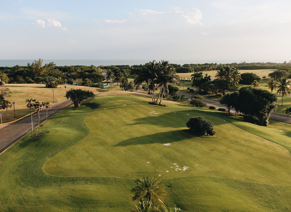aerial view of a coastal golf course fairway lined with palm trees next to the Indian Ocean near Mombasa Kenya