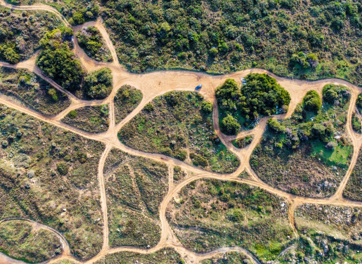 a rocky volcanic track winding through semi-arid scrubland typical of the Losai interior