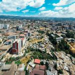 Aerial view of a growing East African city skyline, the kind of urban sprawl surrounding Nairobi where the Magical Kenya Travel Expo convenes each October