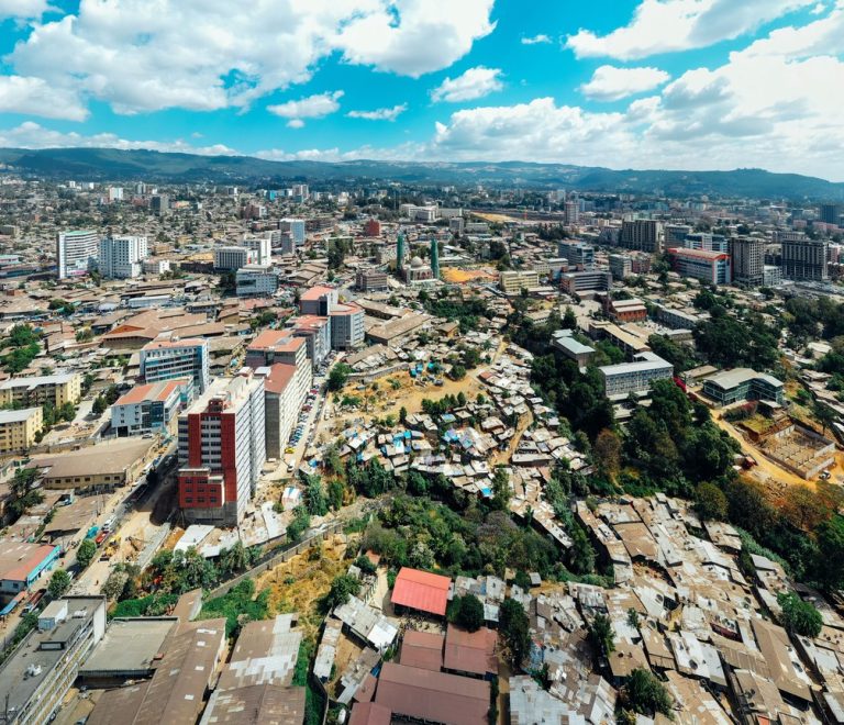Aerial view of a growing East African city skyline, the kind of urban sprawl surrounding Nairobi where the Magical Kenya Travel Expo convenes each October