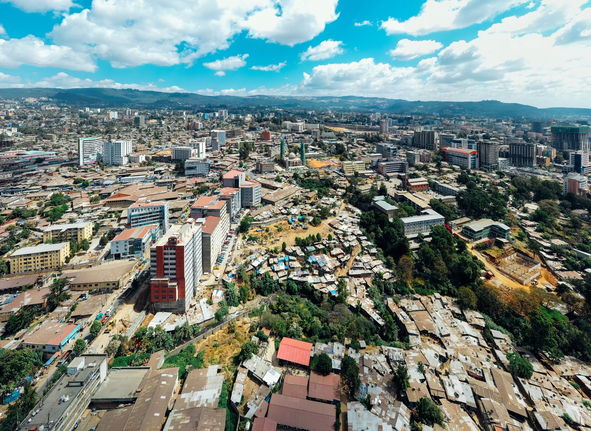 Aerial view of a growing East African city skyline, the kind of urban sprawl surrounding Nairobi where the Magical Kenya Travel Expo convenes each October