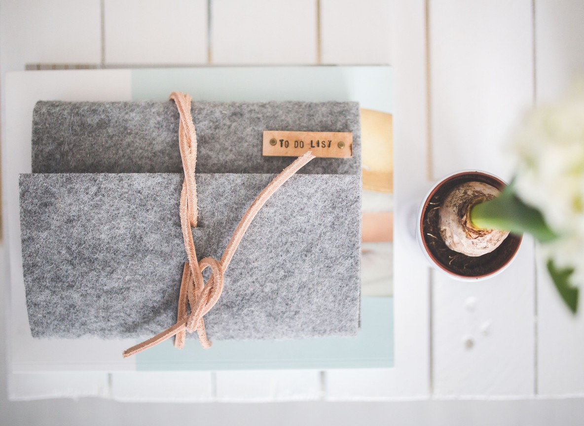 A traveler's notebook and to-do list laid out for trip planning, the homework independent travelers do instead of walking an expo floor