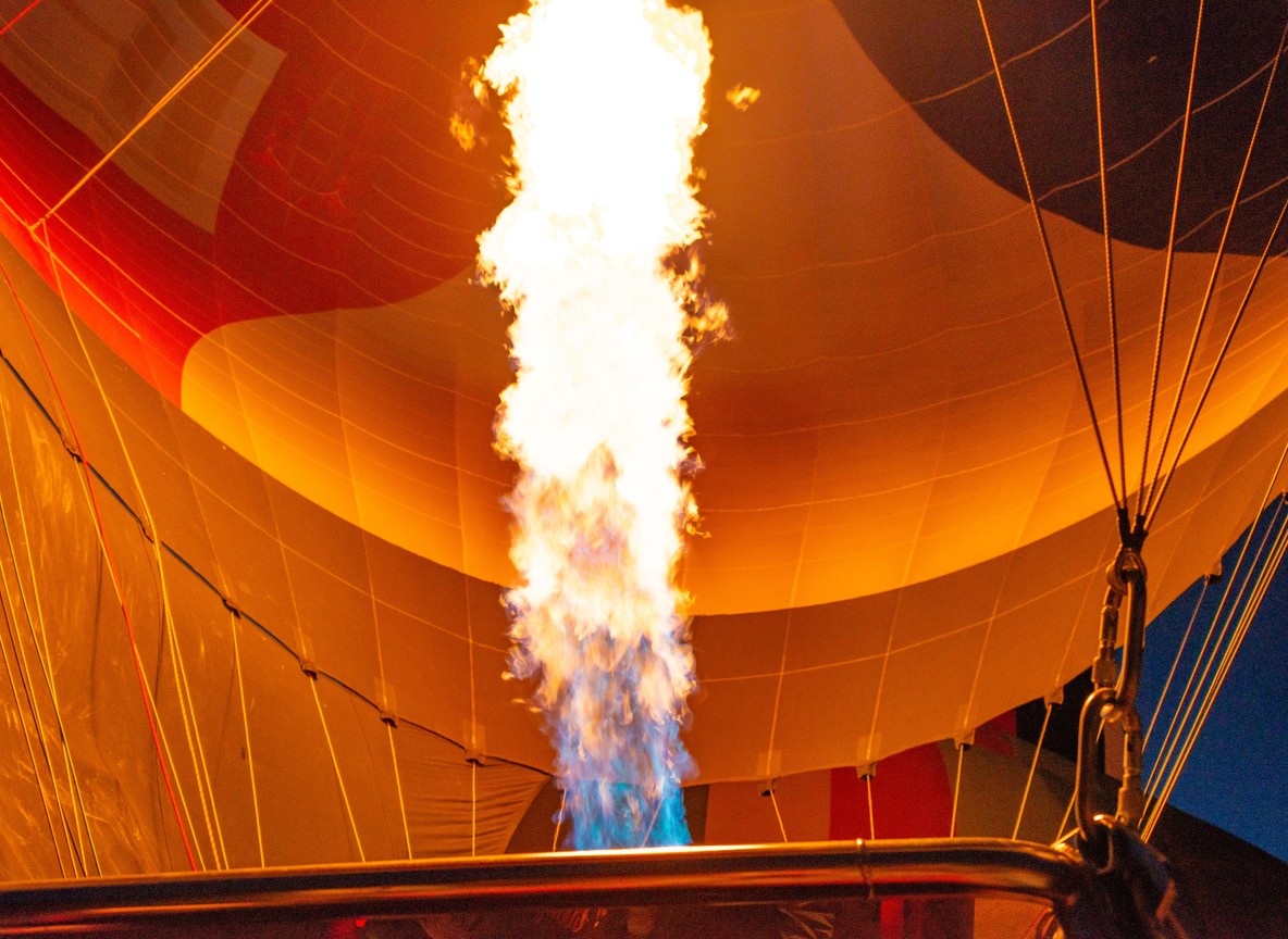 guests boarding a hot air balloon basket at a dawn launch site in the Masai Mara with ground crew holding the envelope