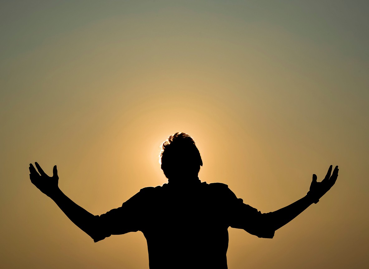 Silhouette of a figure in a yoga pose against a golden sunrise sky at a Kenya safari lodge