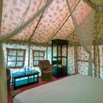 the canopied interior of a luxury safari tented suite, the style of accommodation at Sasaab and Solio Lodge