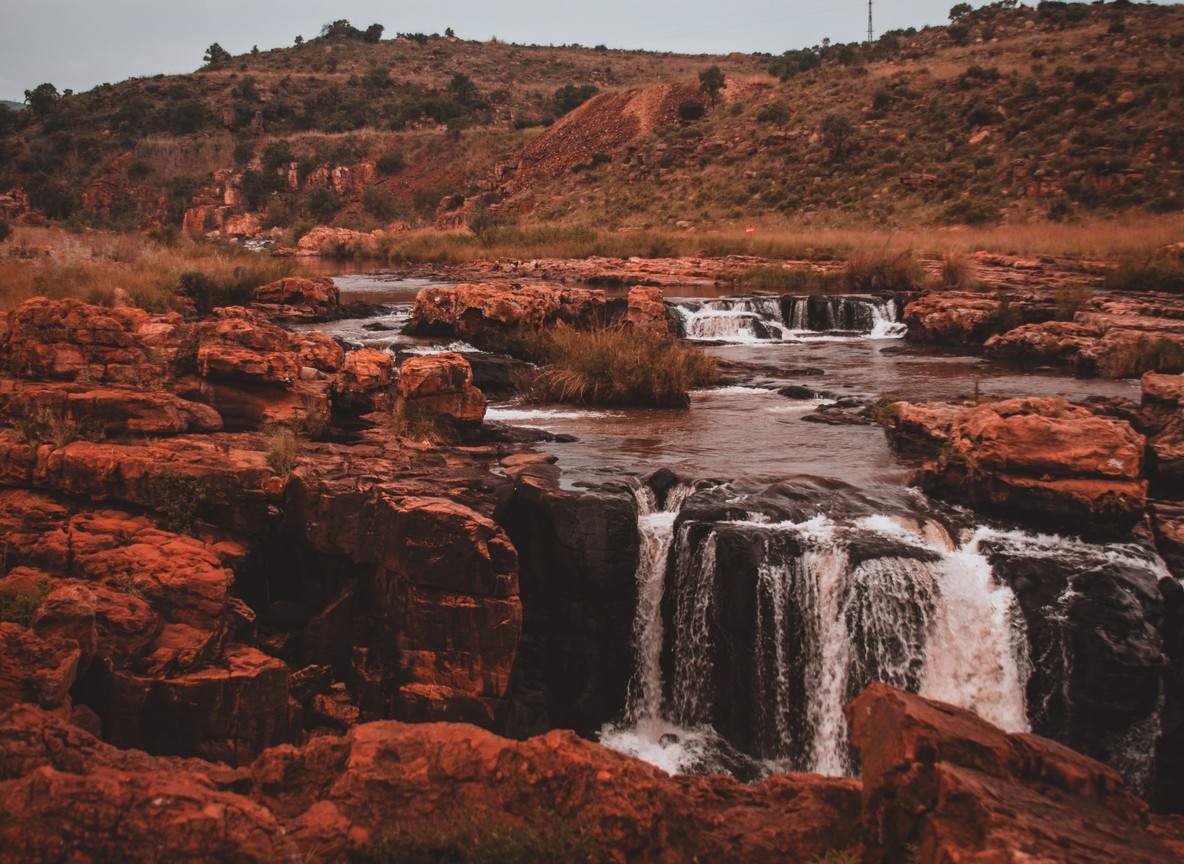 a rocky red-rock river gorge, terrain typical of the river systems cutting through Tsavo's red-soil country near South Kitui