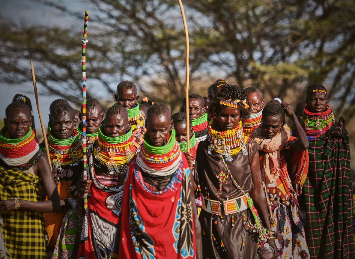 a community scout demonstrating snare removal technique to trainees in dry Tsavo bushland