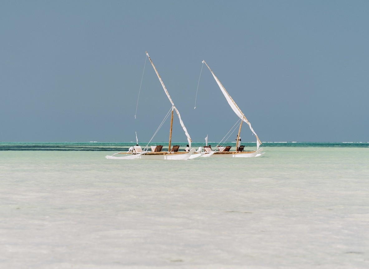 Aerial view of turquoise water and a traditional dhow boat near Nungwi on Zanzibar's north coast