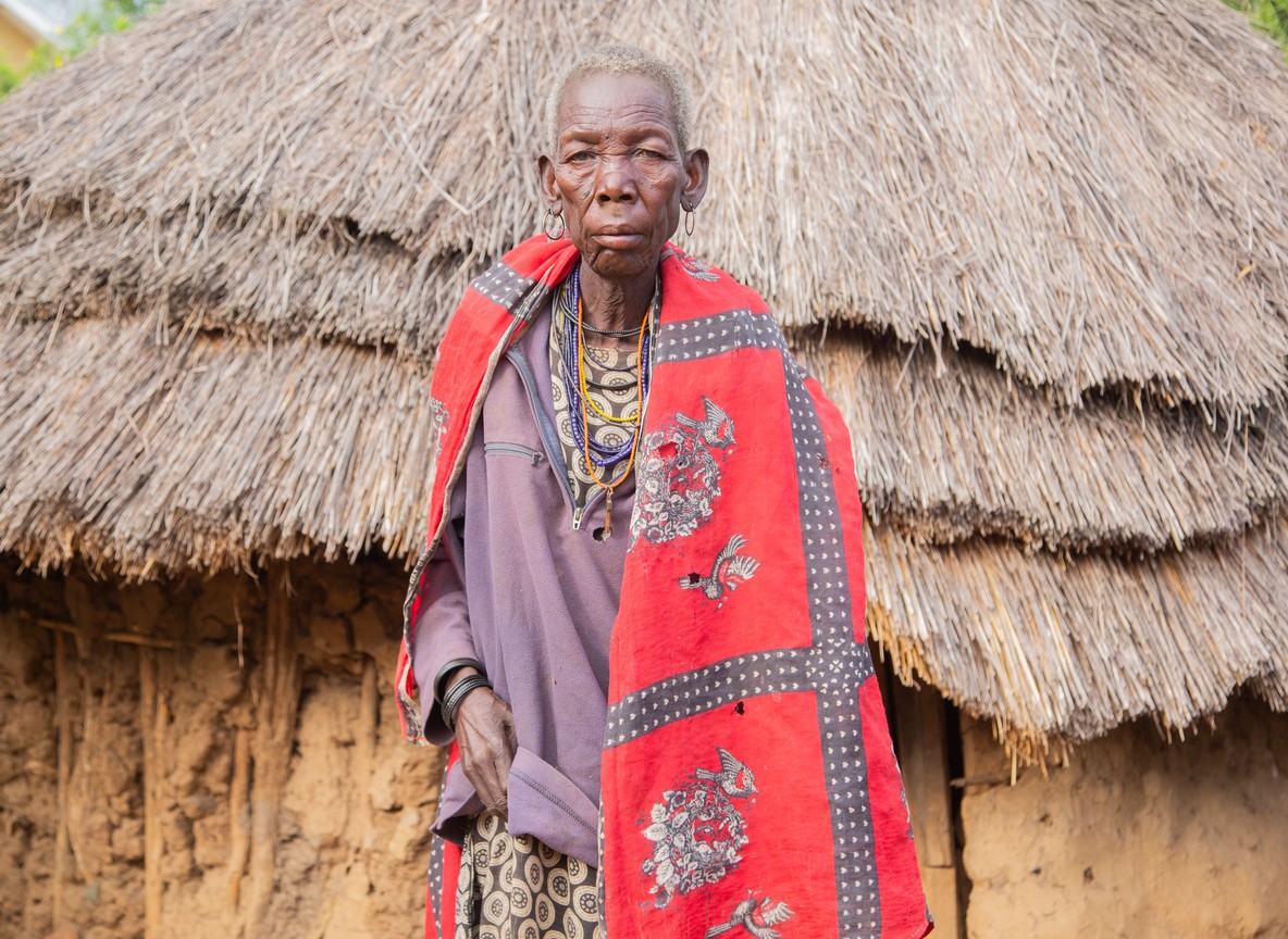 Ranger and Maasai elder reviewing a grazing and land-use map at a conservancy office, wall map of parcel boundaries